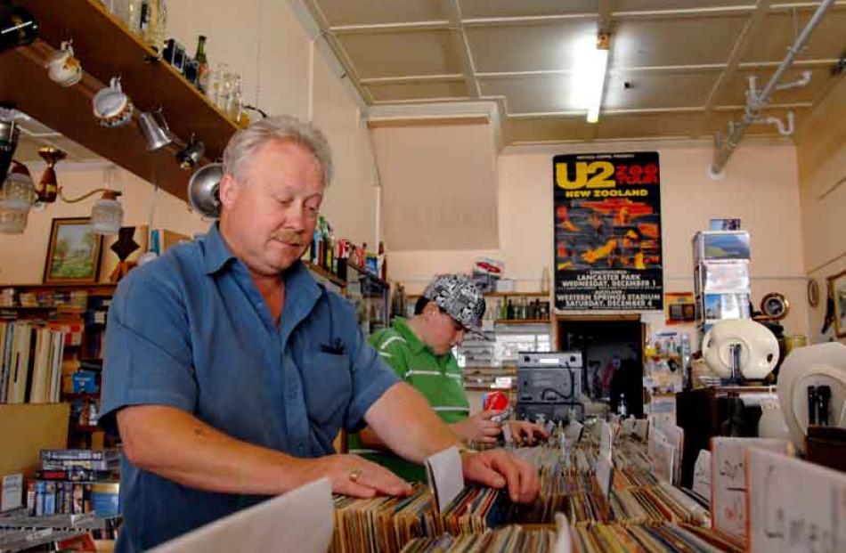 South Dunedin business owner Jim Lloyd flicks through some of his record stock as a customer...