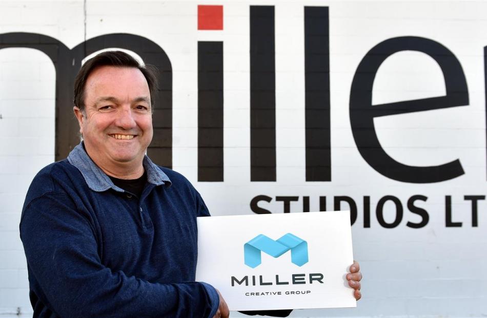 Managing director Keith Cooper holds the  logo for the rebranded Miller Creative Group. Photo by...