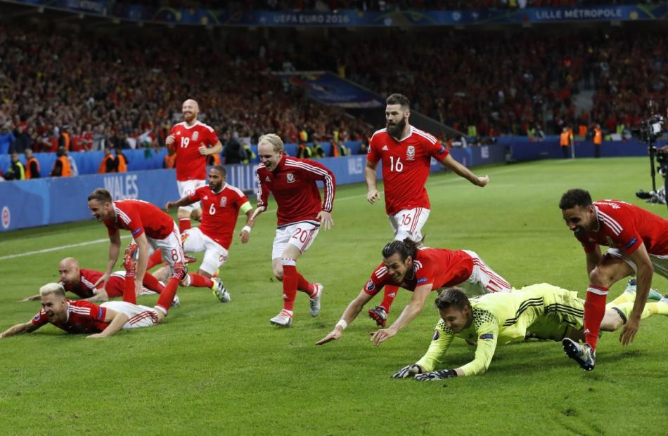 Wales players celebrate their victory at full time. Photo by Reuters