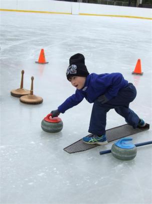 Shaun Thomson (7), of Dunedin, tries his hand at curling. Photos by Lynda van Kempen.
