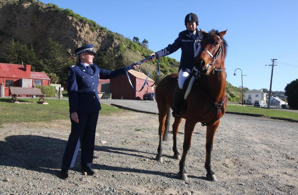 Senior Constable Carrie Hamilton (right) hands the national police baton marking 75 years of...