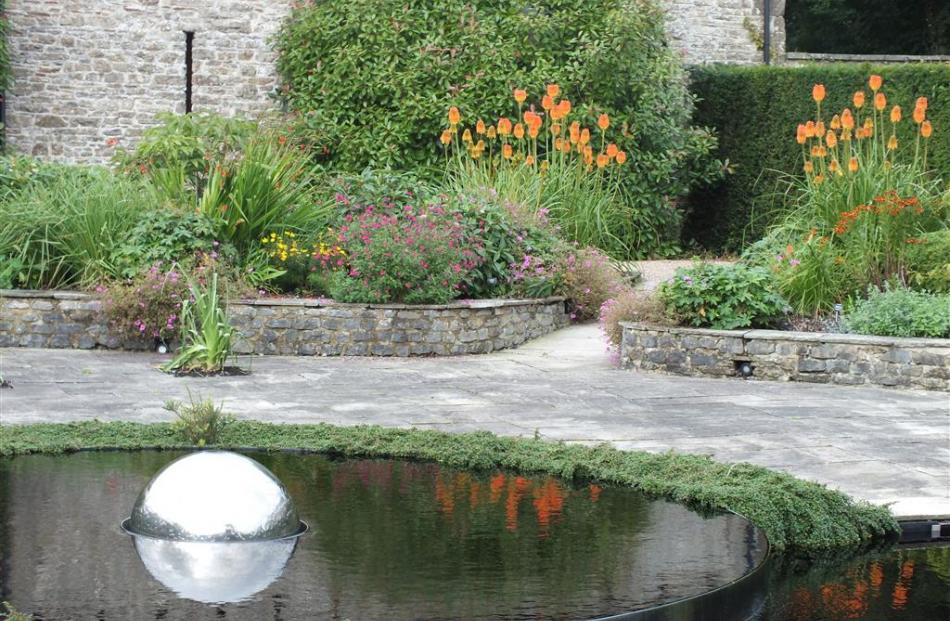 Old stonework frames the hot garden.