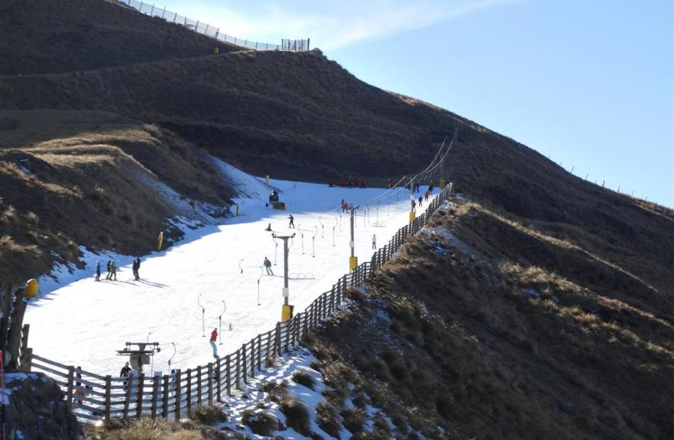 Treble Cone’s beginners’ area is surrounded by tussock-covered slopes after a warm period leading...