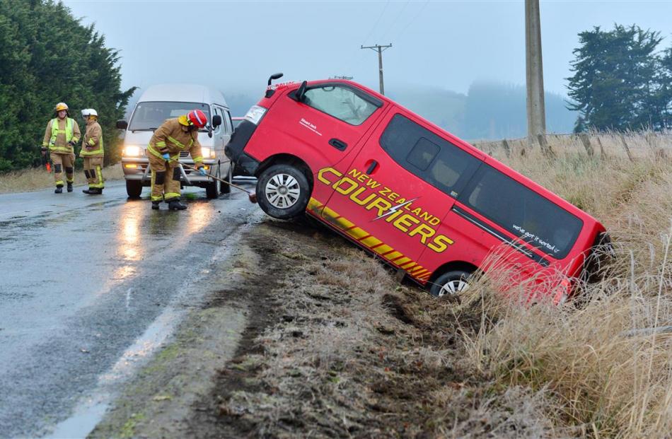 Outram firefighters prepare to tow a New Zealand Couriers van out of a ditch in Henley-Berwick Rd...