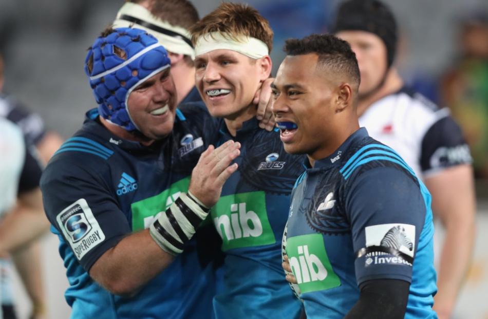 Piers Francis of the Blues (centre) is congratulated on his try from James Parsons (left) and...