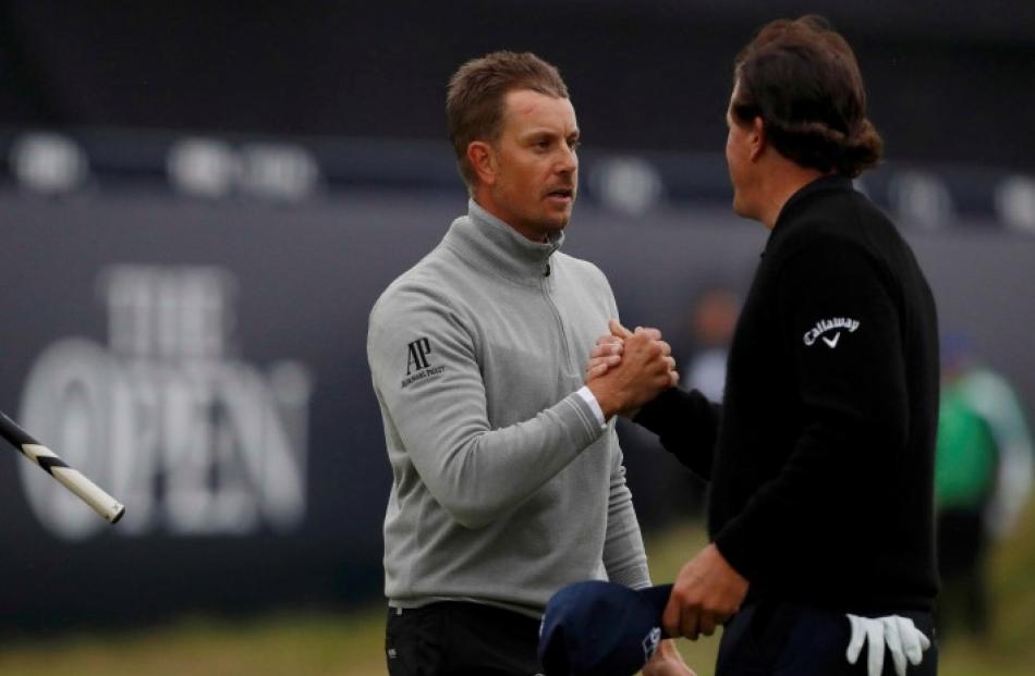 Phil Mickelson (R) and Henrik Stenson shake hands on the 18th green during the third round. Photo...