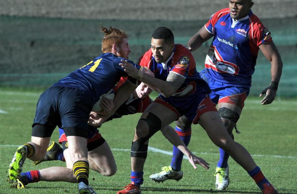 Dunedin winger Liam Ward is tackled by Harbour back Marckis Schaaf during their premier semifinal...