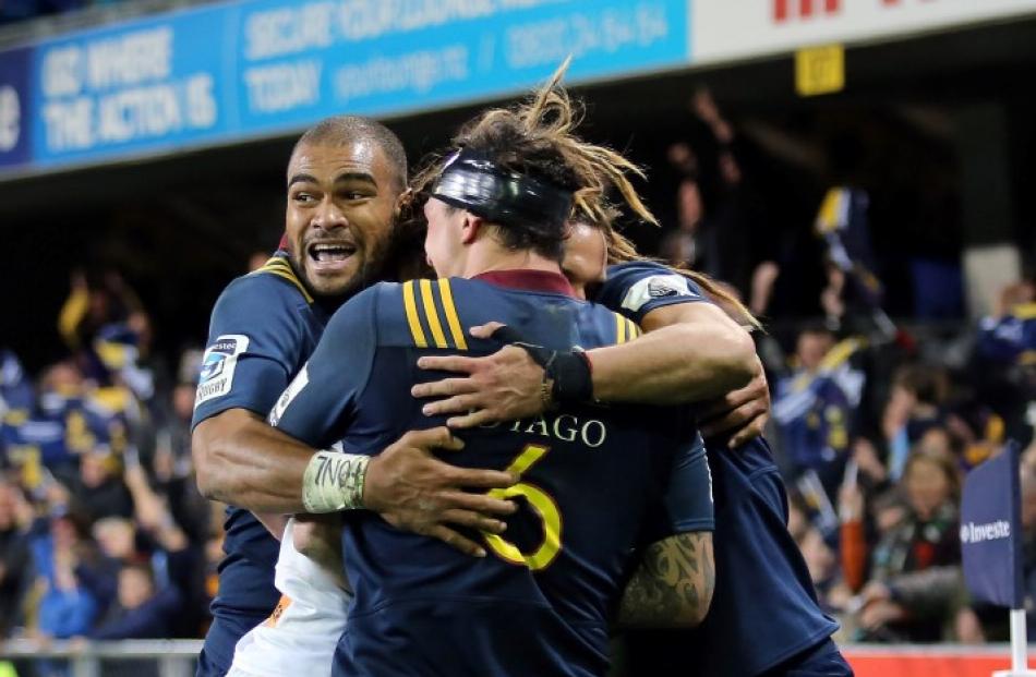 Chiefs first five Aaron Cruden gets caught in the huddle as Highlanders players celebrate Dan...