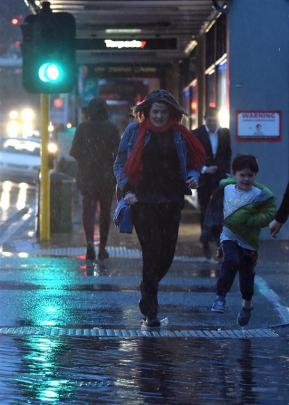 Pedestrians run across Stuart St as what started as a warm and fine day in Dunedin gave way to...