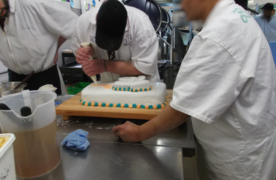 An Otago Corrections Facility prisoner adds the finishing touches to a celebratory cake marking...