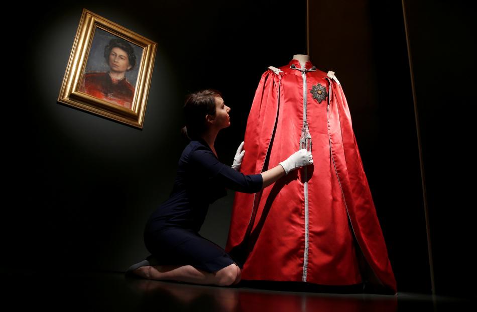 A member of the Royal Collection Trust with the Queen's Mantle of The Order of The British Empire...