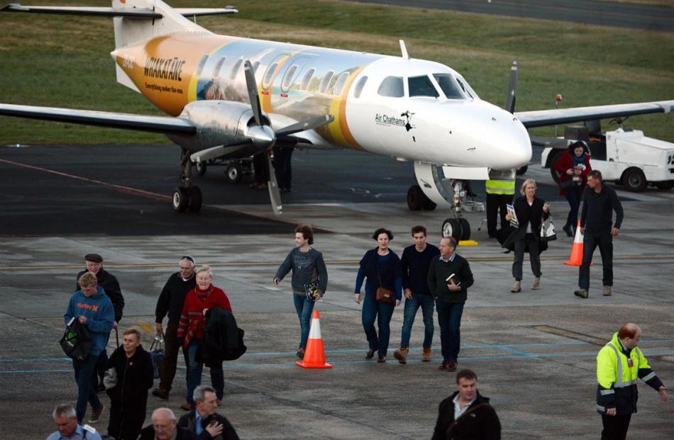 Passengers disembark from their late flight into Dunedin.