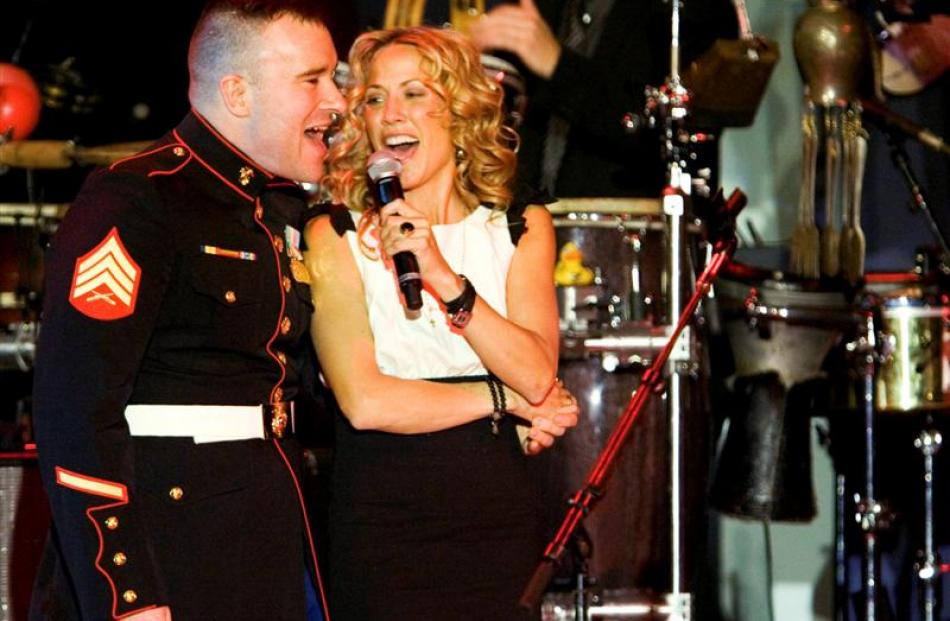 Singer Sheryl Crow is joined by an unidentified US Marine during her performance at the...