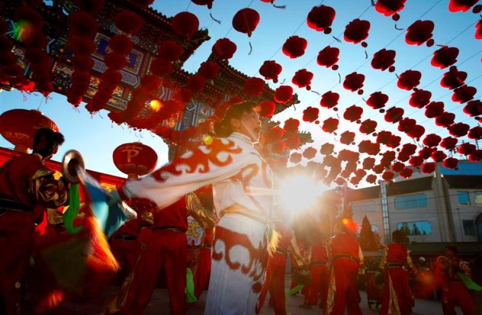 Dancers dressed in traditional Chinese costumes perform at the opening ceremony of a temple fair...