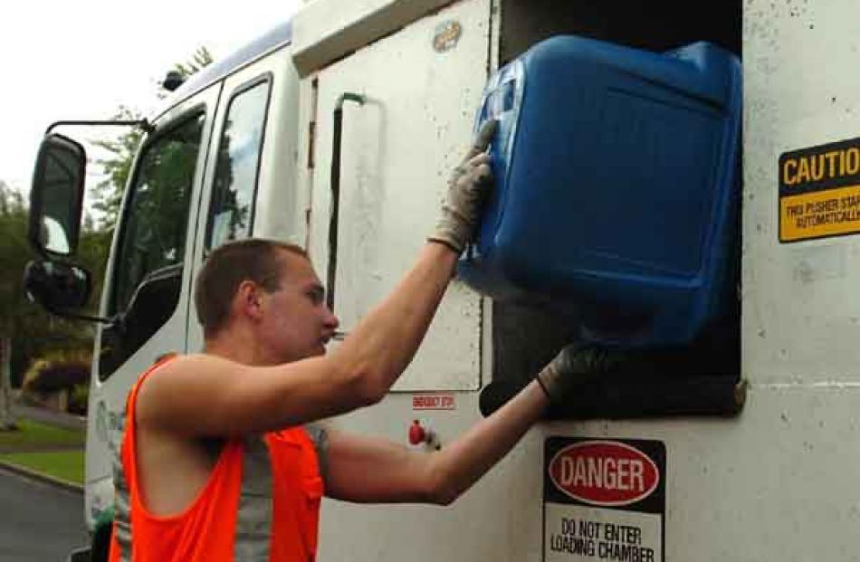 2. Recycling runner Ken McDonald loads containers into a recycling truck.
...