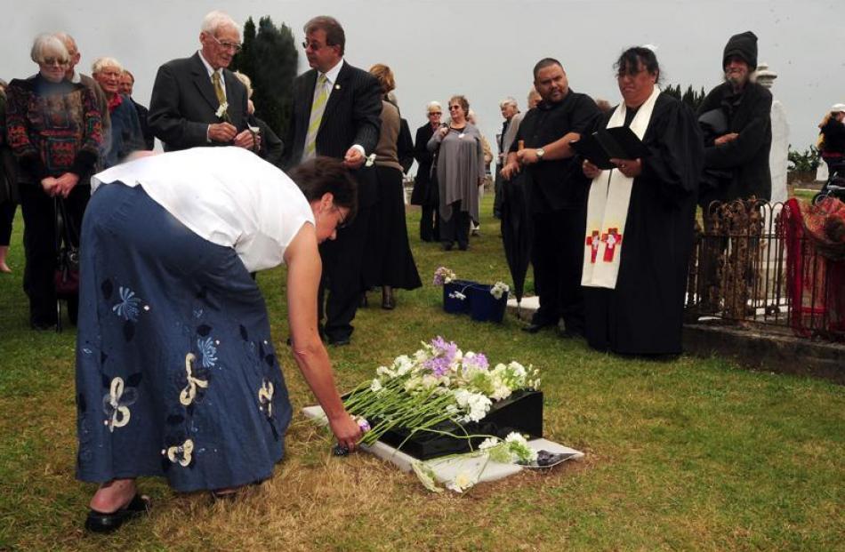 Paula Wells, a descendent of Minnie Dean,  lays flowers on the grave.