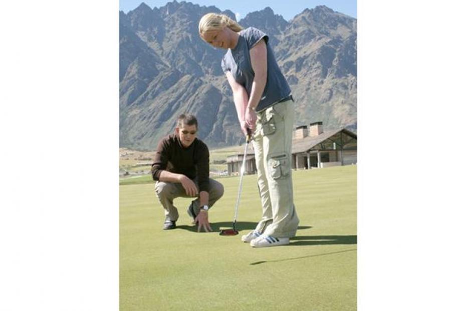 Tracey Roxburgh putts the ball in the hole! Teacher John Griffin and the Jack's Point Clubhouse...