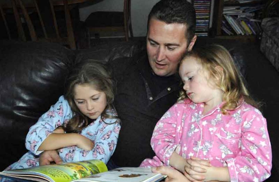6:50pm: Philip Marsh, of Waldronville, reads a bedtime story "Quiet" to his daughters Jennifer (6...