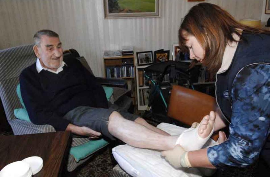 3:00pm: Registered District Nurse Angela Koopman carries out wound care on the feet of Stan...
