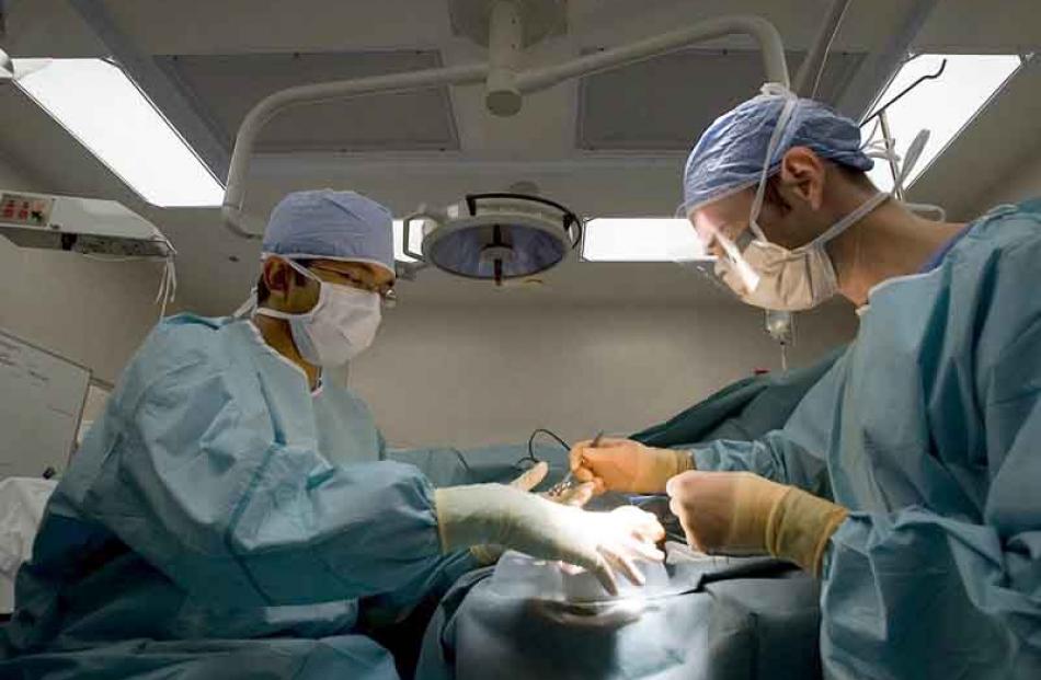 9:30am: Staff perform an operation at Dunedin Hospital. Photo: Ian Thomson