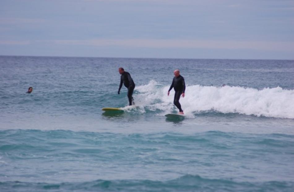 Mick McHugh (left) and Bill Cleland enjoy the surf at St Clair. Photo by Mark Russell.