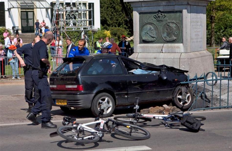 Police officers surround the car moments after it slammed into a monument. (AP Photo/Cynthia Boll)