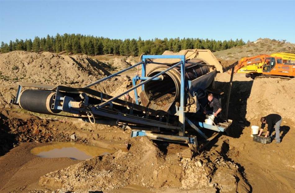 Gold miners remove the mats from their gold screen at the end of another day.