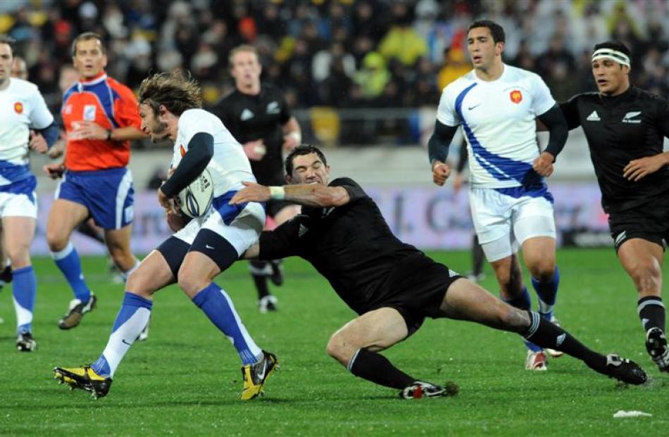 France's Maxime Medard , left, is tackled by New Zealand's Stephen Donald. Credit:NZPA / Ross...