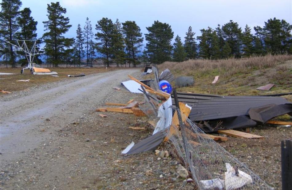 Debris from a Gilmore Rd implement shed north of Cromwell litters an adjacent fence and...