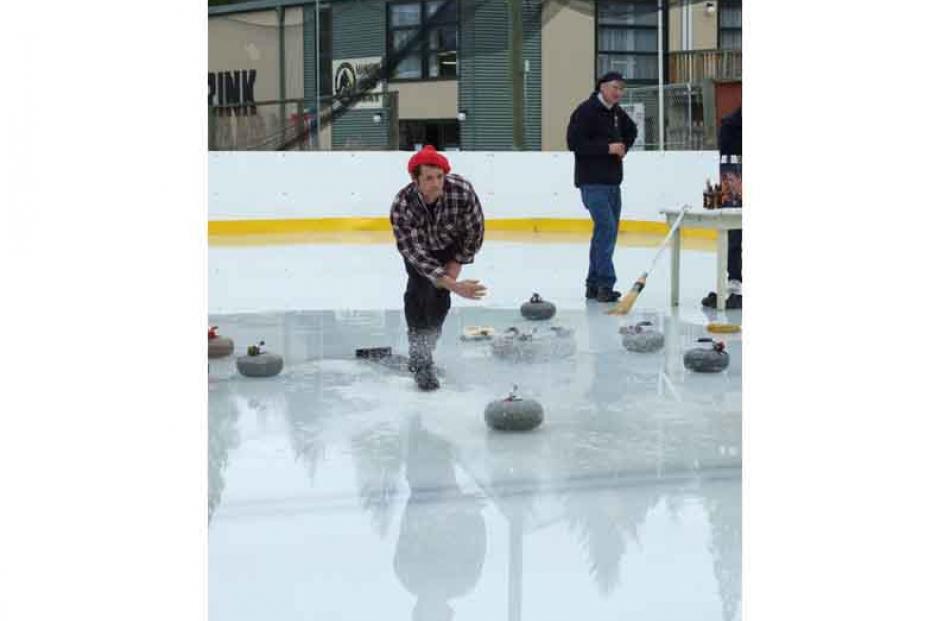 Stewart McConnell (Alpine Club) delivers a stone. The new indoor rink, visible at rear, was used...