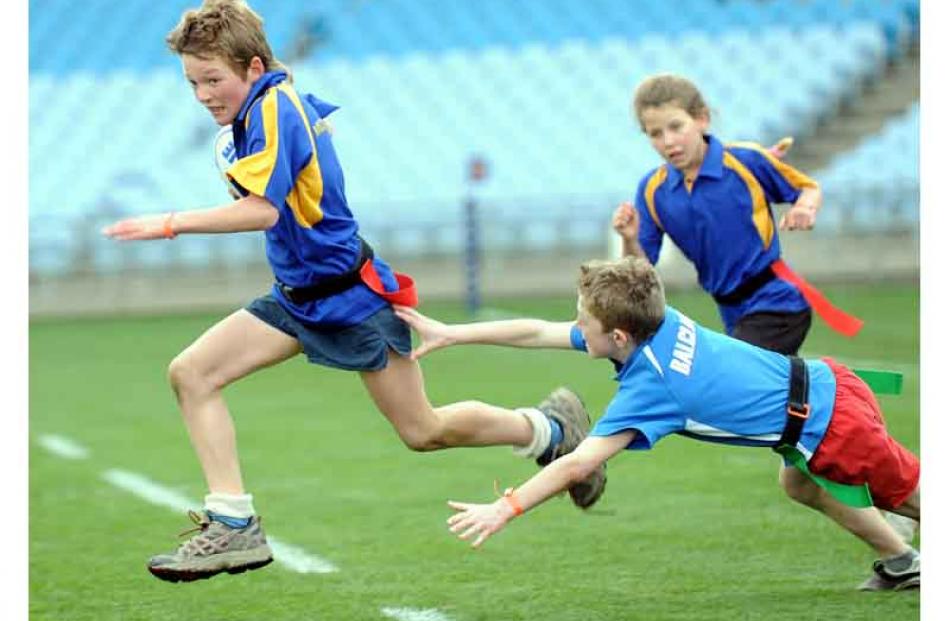 Kane Johnston (10), of Millers Flat Primary School, slices through Zac Thoms (10), of Balclutha...