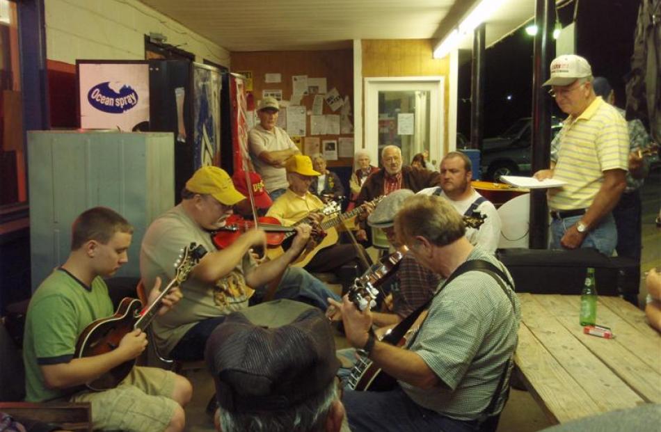 Guitar, banjo and mandolin players (left) converge in the town of Stuart,  for the Thursday night...