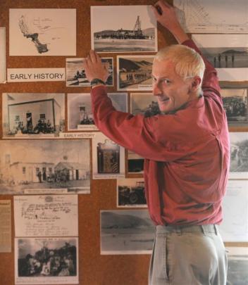 Aramoana League committee member Gordon Tocher hangs photos at an exhibition tracing the history...