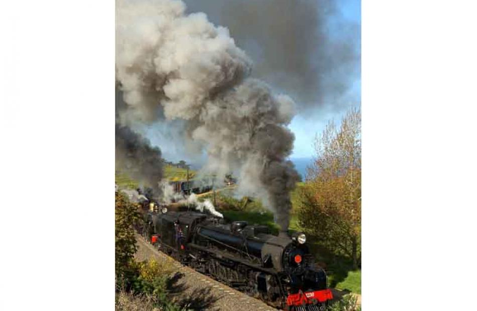 Steam locomotives JB1236 (front) and Ab663 puff their way up an incline into Seacliff during...