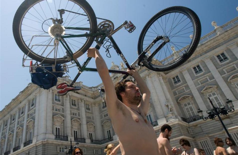 A cyclist shows his bicycle after riding naked through central Madrid. Photo by AP.