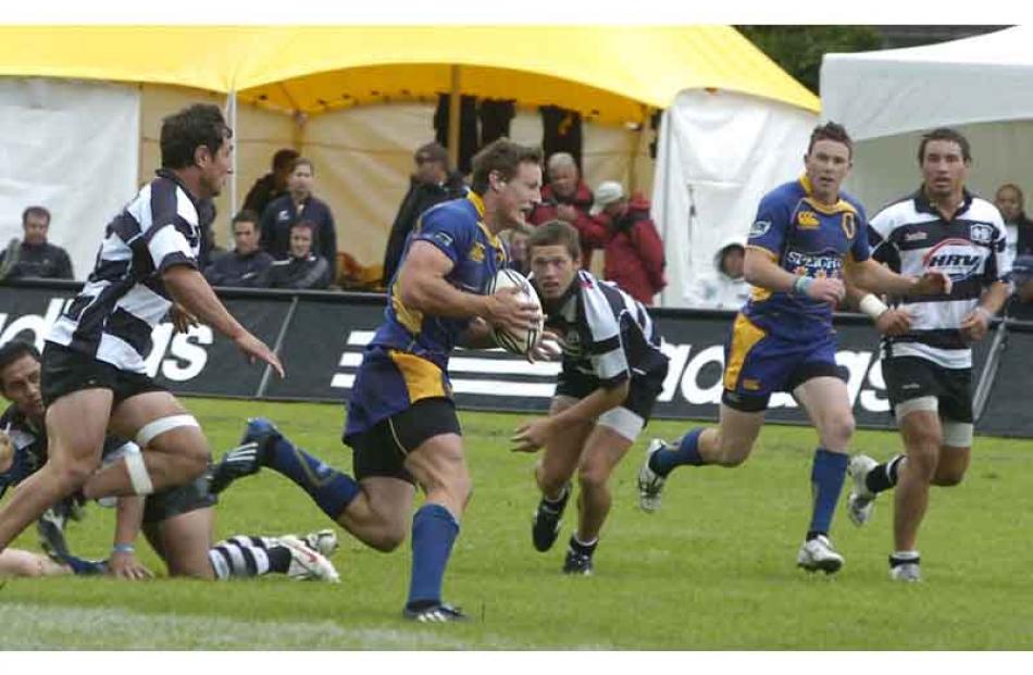Glenn Dickson of Otago runs with the ball chased by Carl Anderson of Hawkes Bay.
