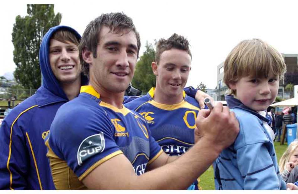 Otago player, Johnny Legg signs the shirt of Albie O'Connell (6) of Queentsown while (from left)...
