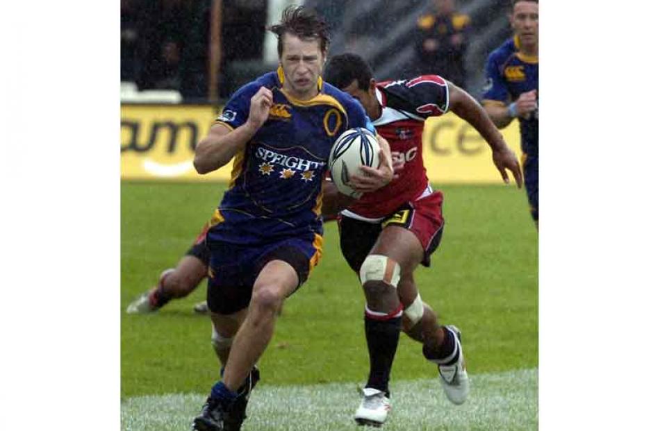 Marshall Suckling, Otago, runs with Siale Piatau of Counties Manukau chasing through the rain.