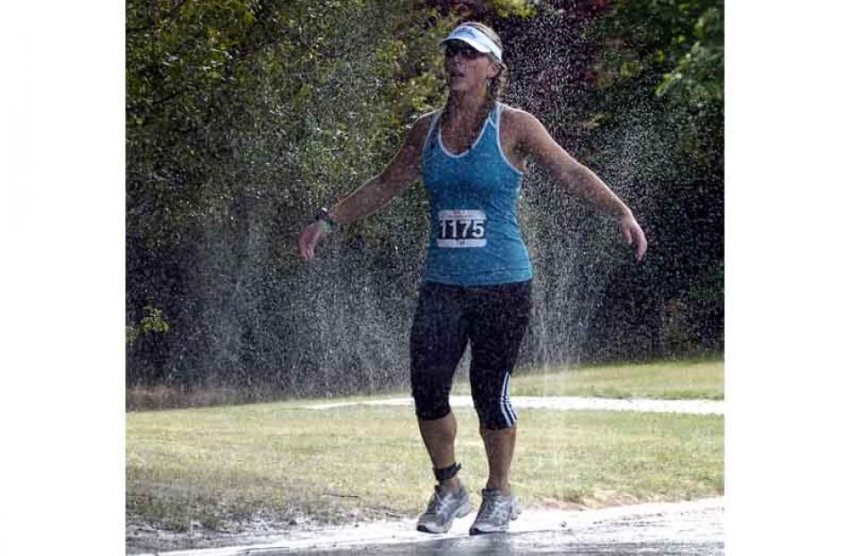 Tui Russell of Wanaka soaks up water from a roadside sprinkler. Photo by Jane Dawber.