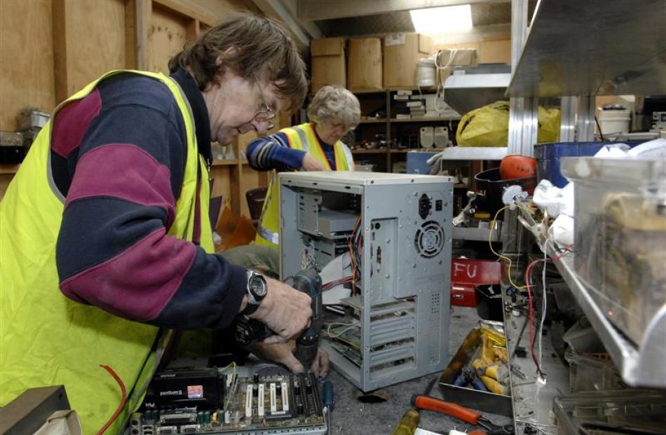 Peter Garron and Anne Farquharson dismantle computer equipment for recycling at Cargill...