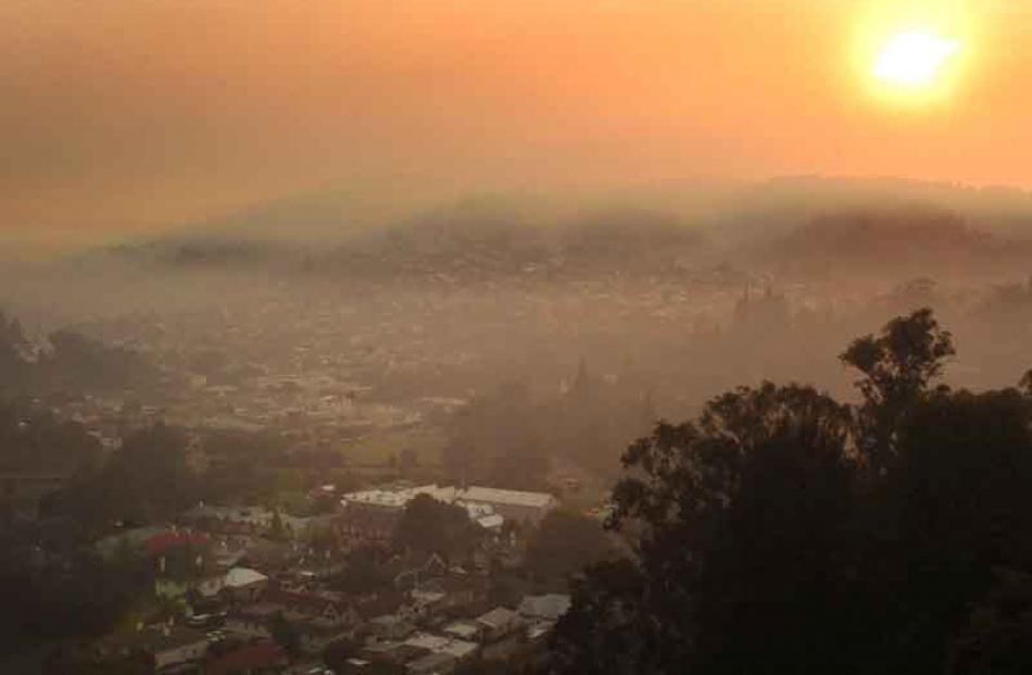 North East Valley is bathed in an eerie glow as morning sun shines through smoke yesterday. Photo...