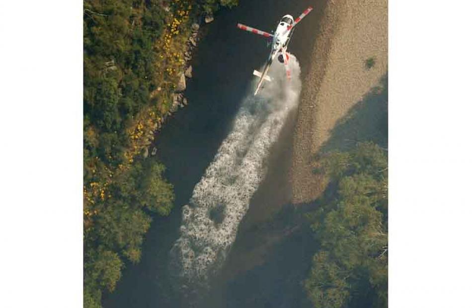 A pilot fills a monsoon bucket from the Taieri River. Photo by Gerard O'Brien.