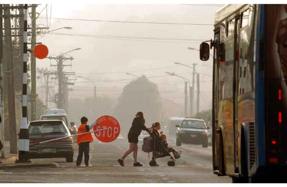 Parents and pupils arrive at North East Valley Normal School yesterday morning surrounded by a...