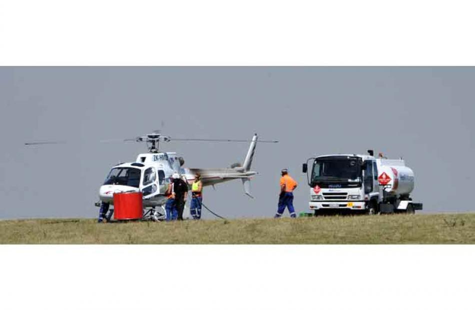 A helicopter is refuelled from a tanker. Photo by Peter McIntosh.