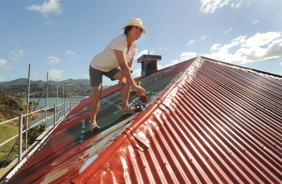 Former caretaker Kathy Morrison paints the roof.