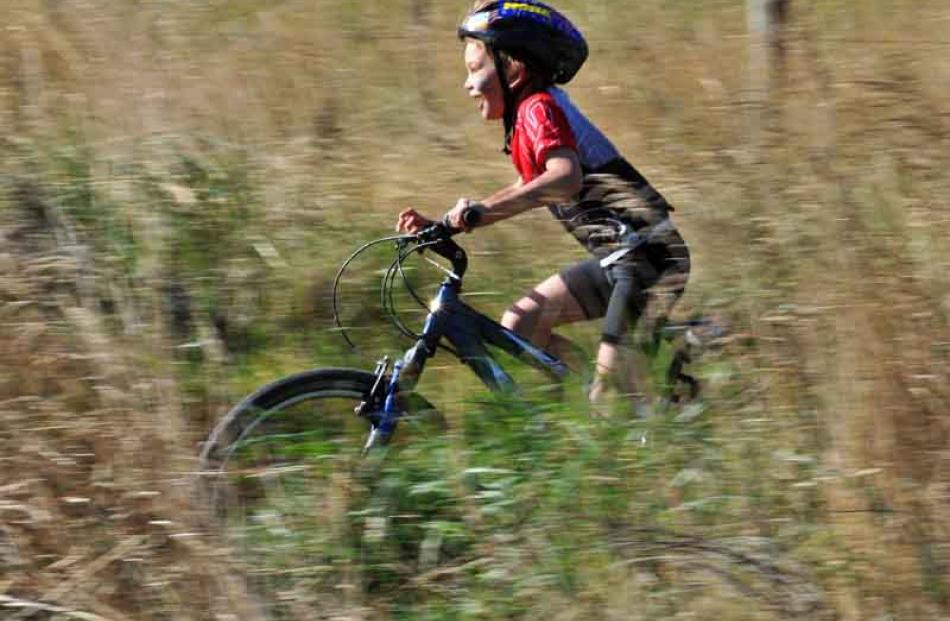 Billy Sheard (8) tears through the long grass during the Kids' Bike Jams organised by Sport Otago...