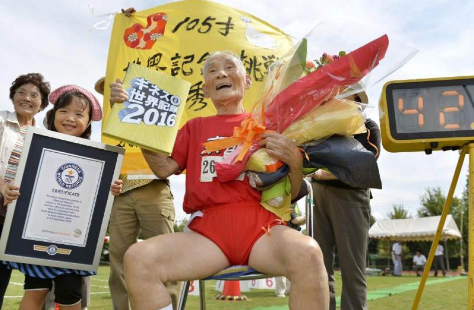 105-year-old Japanese Hidekichi Miyazaki poses for photos at an athletic field after becoming the...