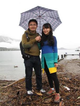 Lei Huang and Xlaolu Du, of China, did not mind the waterfront debris left by a swollen Lake...