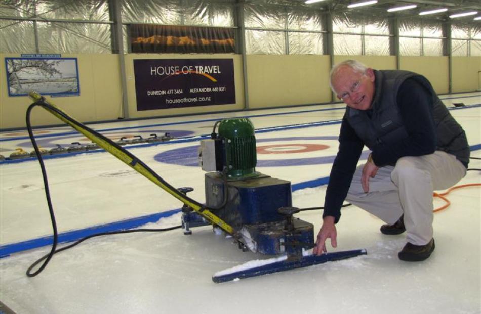 Maniototo Curling International Inc manager Bruce McCormick clears ice from the machine used to...