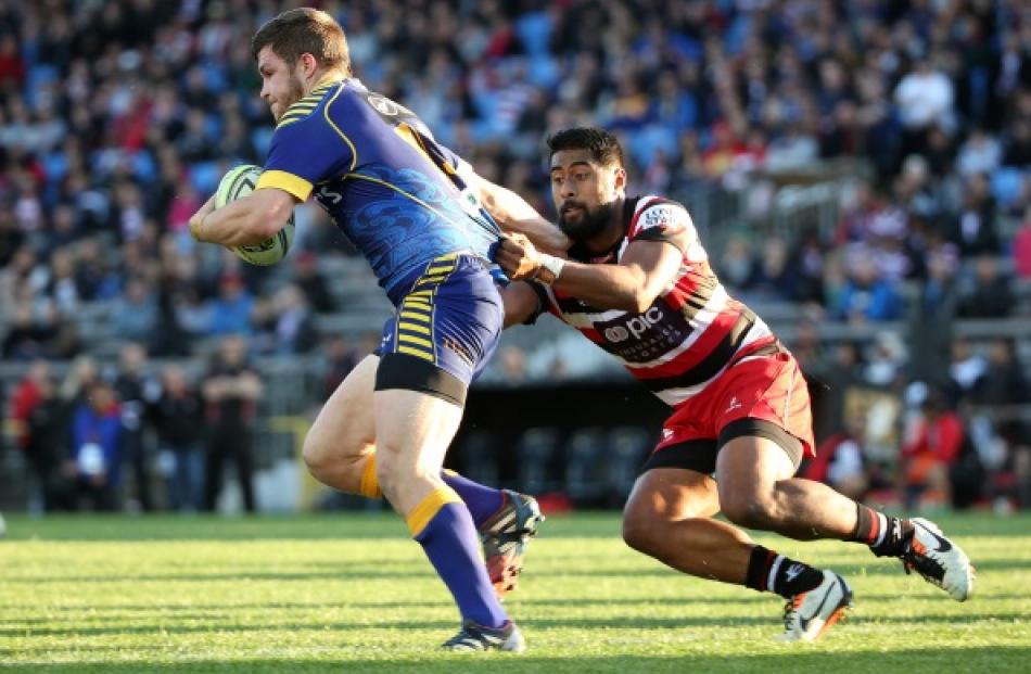 Otago's Michael Collins (L) is tackled by Counties Manukau first five Ahsee Tuala during the...